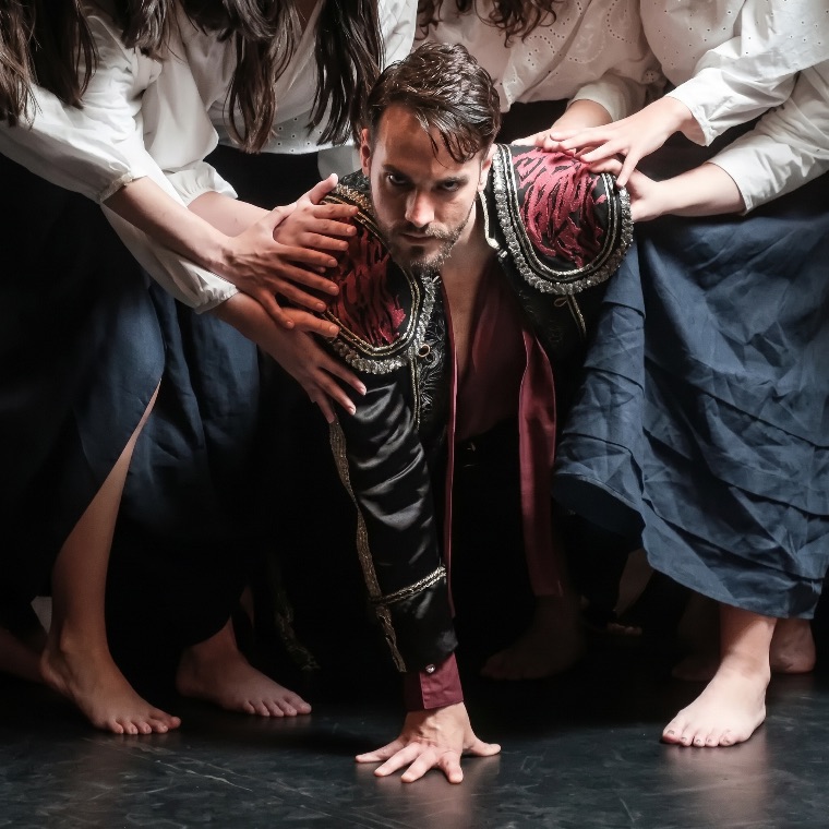 Luka Jozic kneeling, surrounded by reaching hands